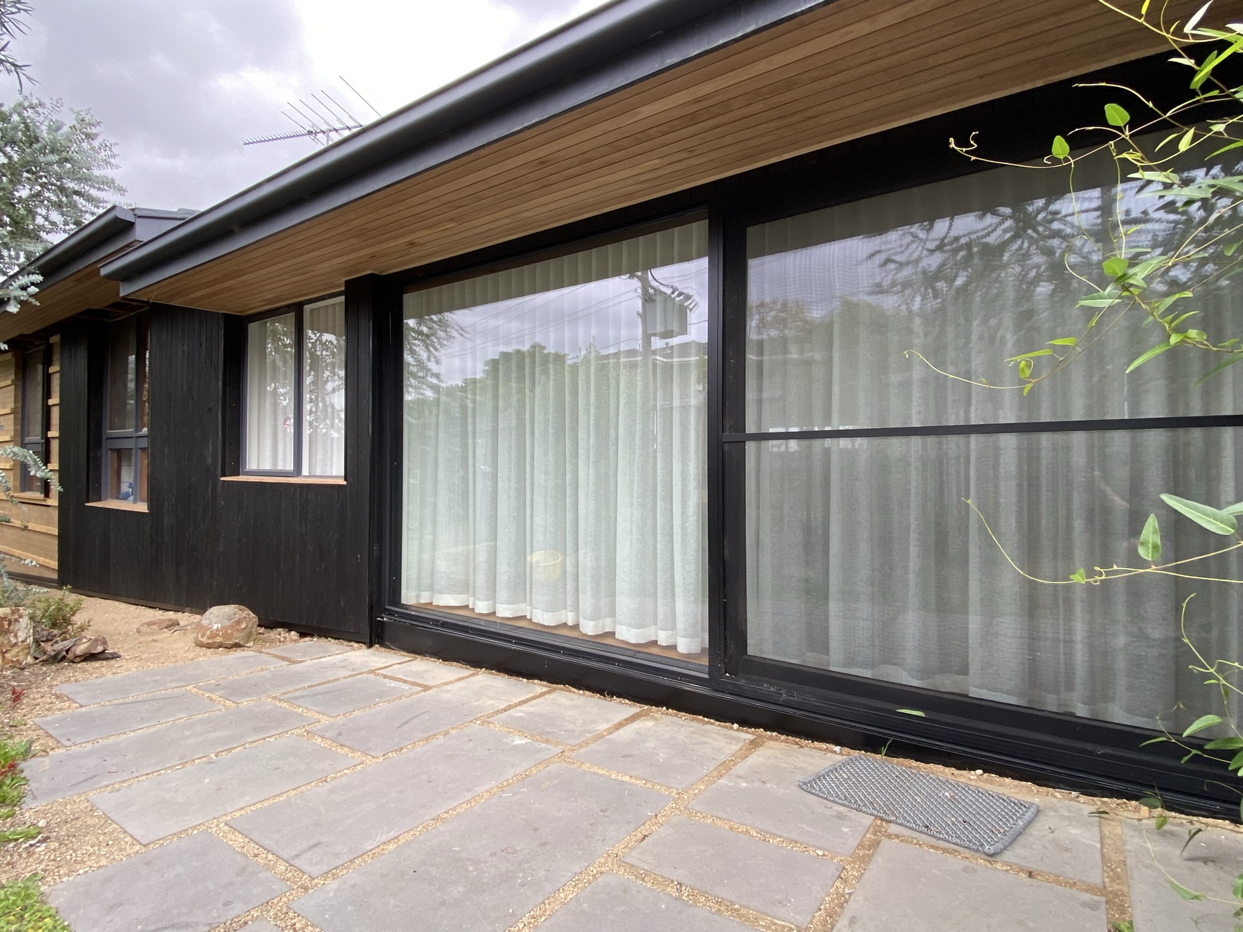 Dark timber cladding with timber-lined eaves